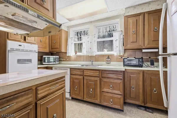 a kitchen with cabinets wooden floor and a window