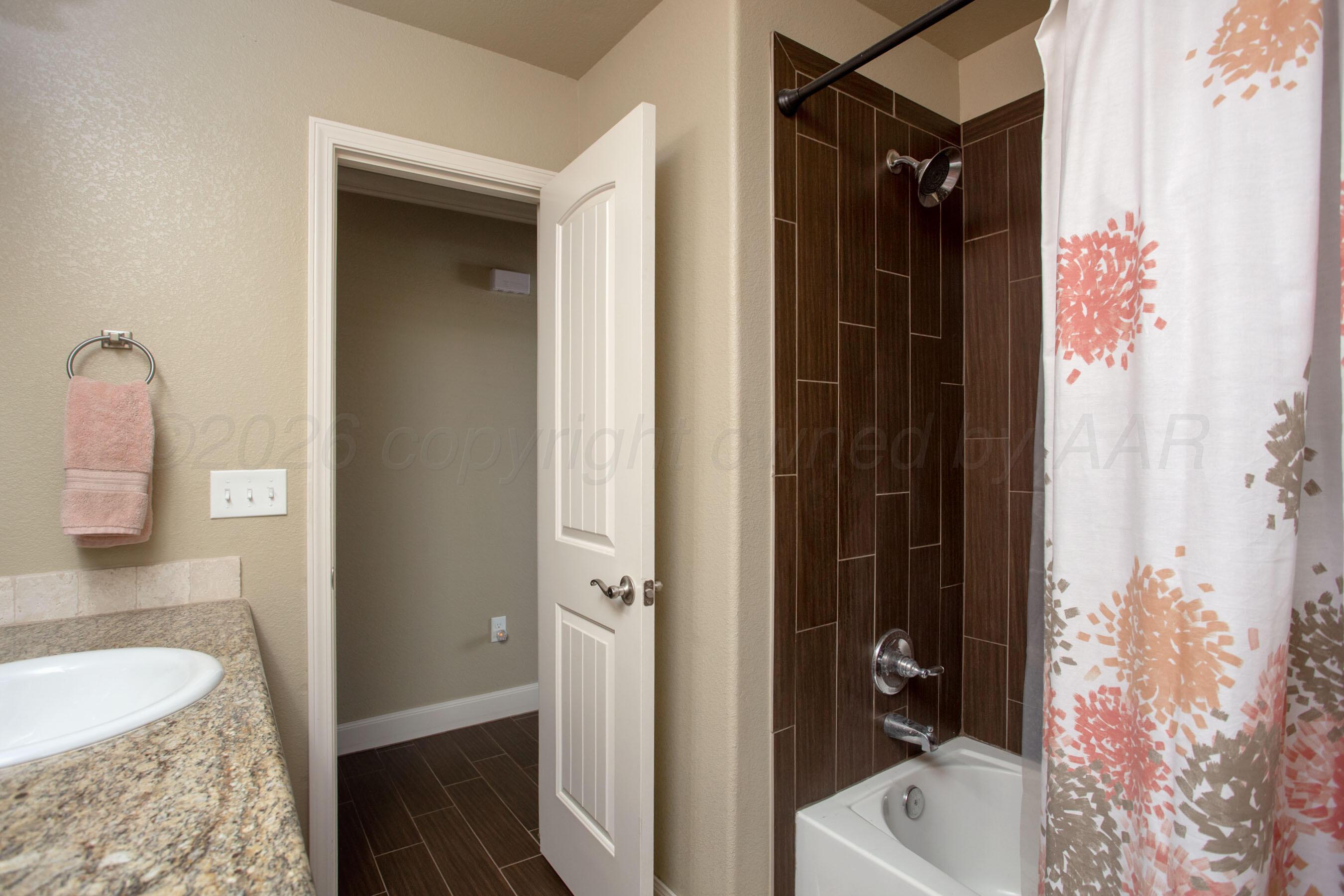 4812 Gloster Street Amarillo, TX 79118 - Photo 11 of 16 a bathroom with a granite countertop tub sink and mirror