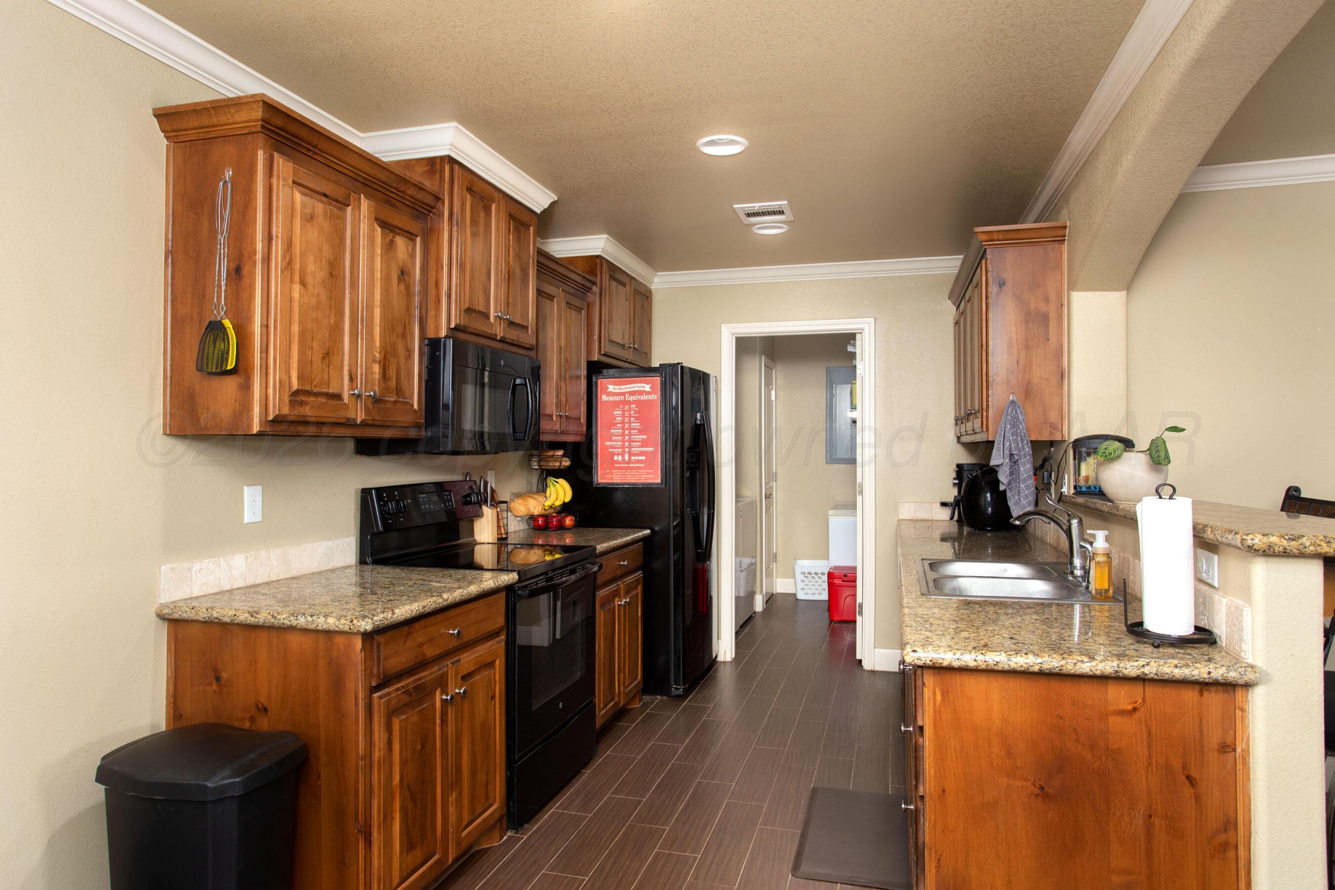 4812 Gloster Street Amarillo, TX 79118 - Photo 4 of 16 a kitchen with stainless steel appliances granite countertop a sink stove and refrigerator