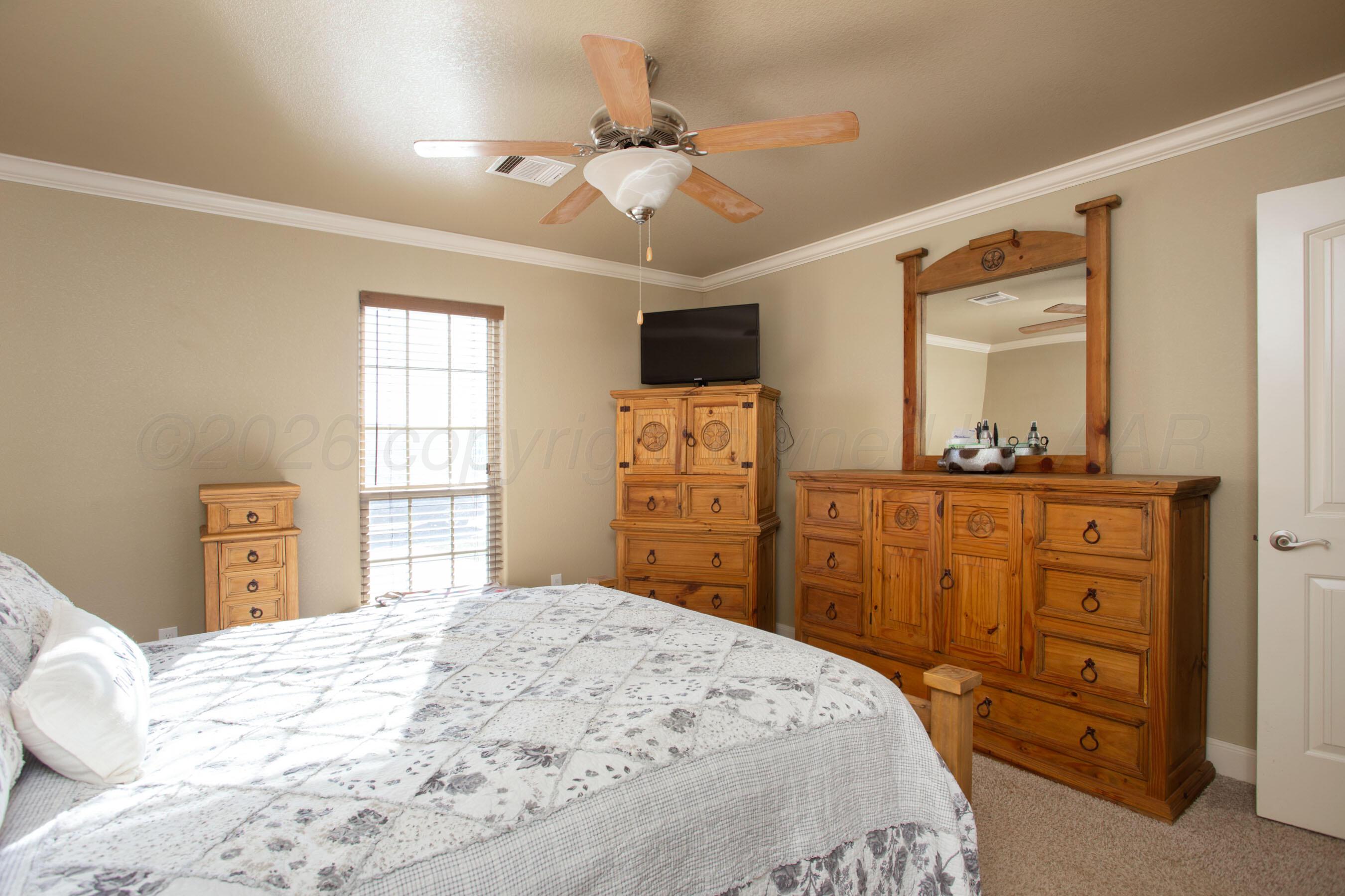 4812 Gloster Street Amarillo, TX 79118 - Photo 6 of 16 a bedroom with a bed a dresser and a large mirror