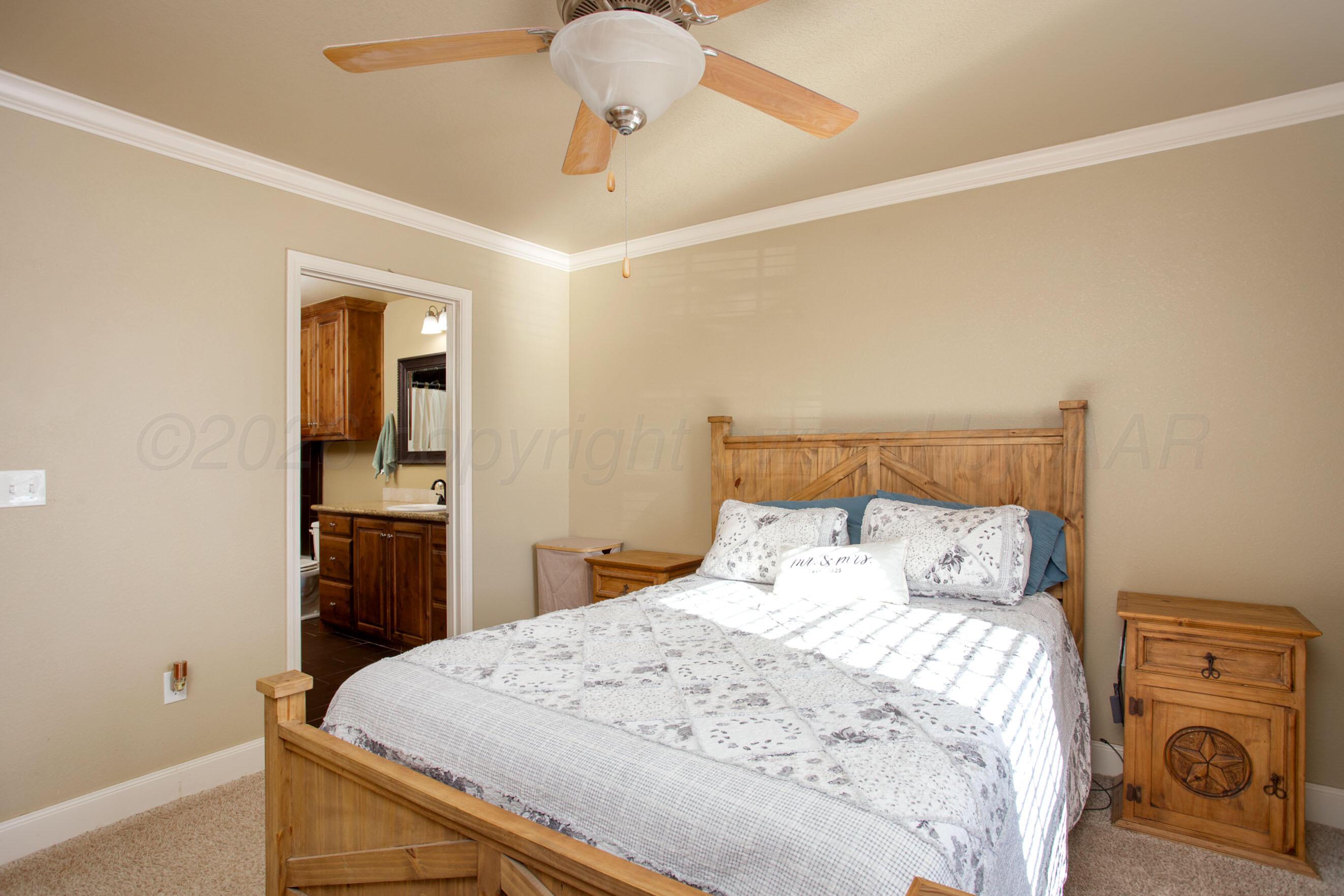 4812 Gloster Street Amarillo, TX 79118 - Photo 7 of 16 a bedroom with a bed and a chandelier