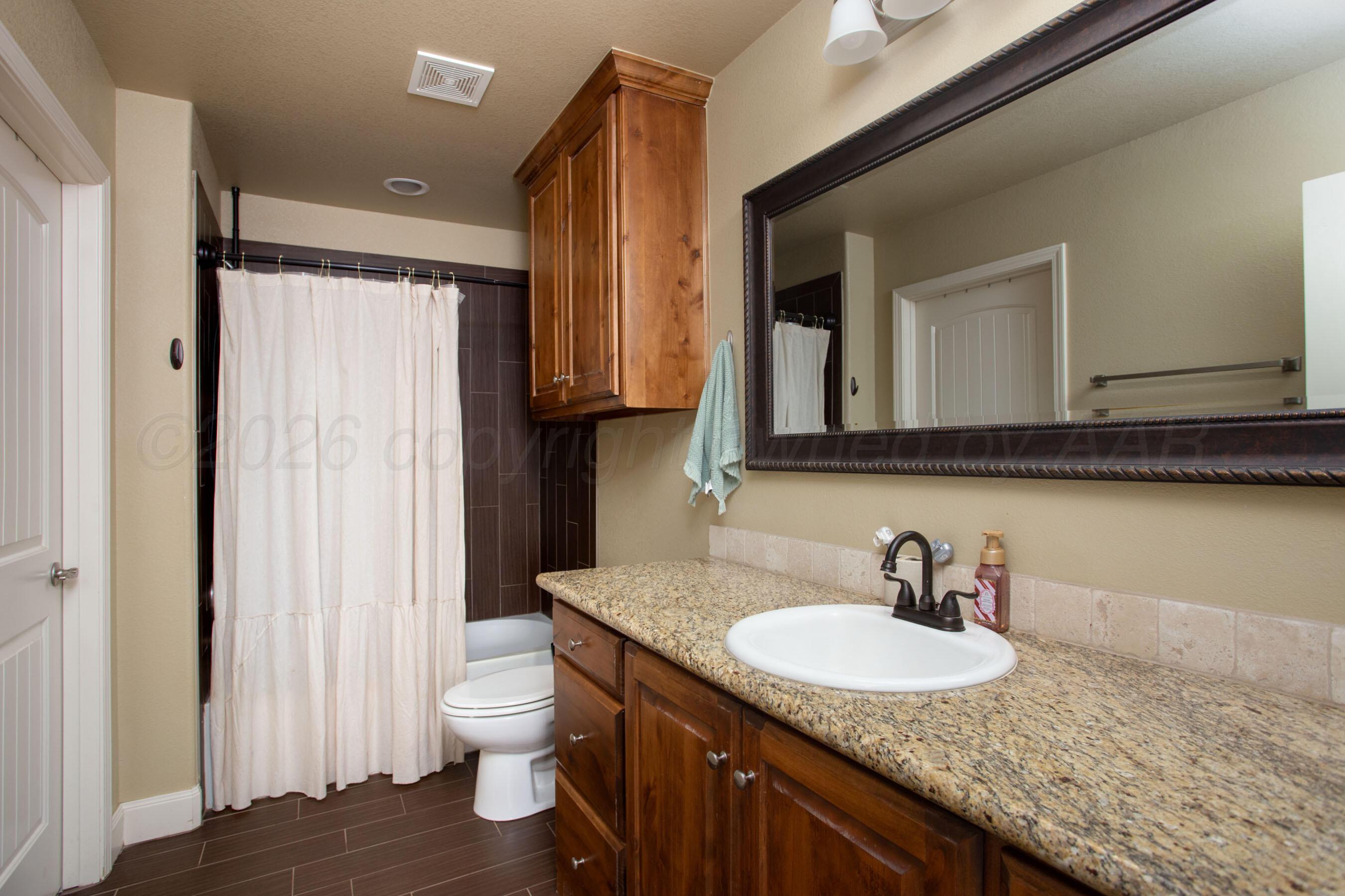 4812 Gloster Street Amarillo, TX 79118 - Photo 8 of 16 a bathroom with a granite countertop sink and a toilet