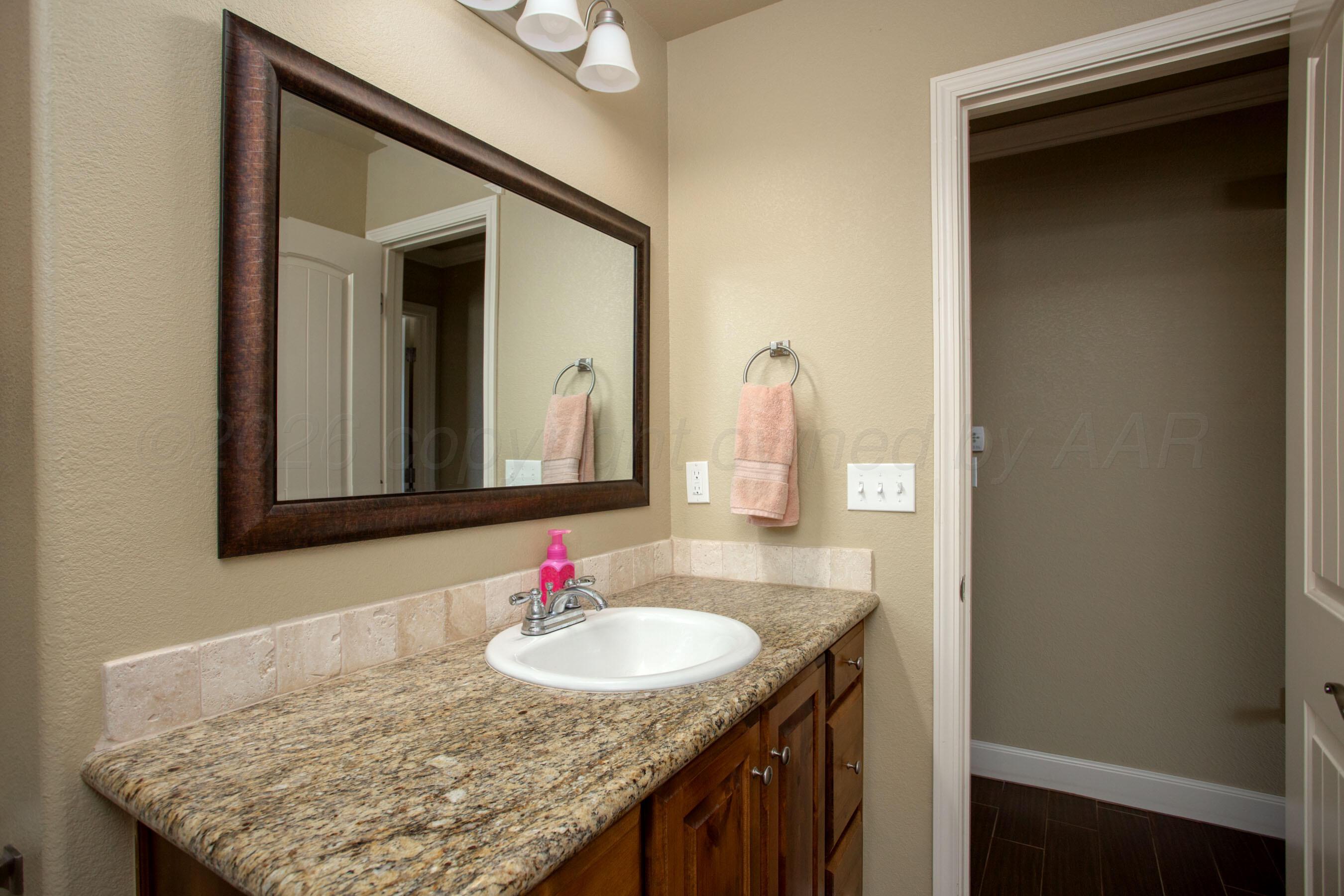 4812 Gloster Street Amarillo, TX 79118 - Photo 10 of 16 a bathroom with a granite countertop sink and a mirror