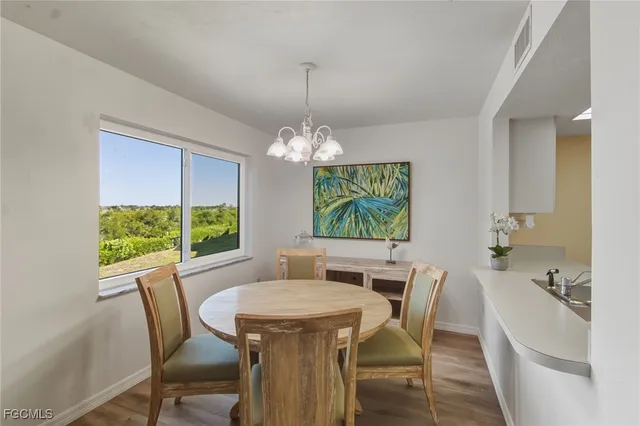 a dining room with furniture a chandelier and window