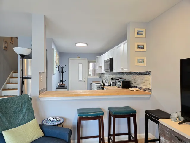 a kitchen with a stove a sink a oven a dining table and chairs