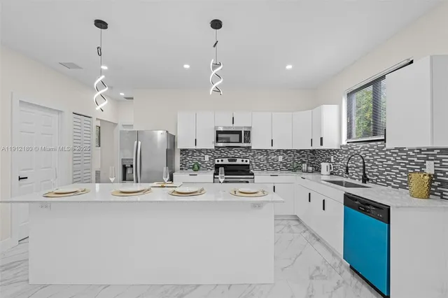 a kitchen with stainless steel appliances kitchen island granite countertop a sink and cabinets