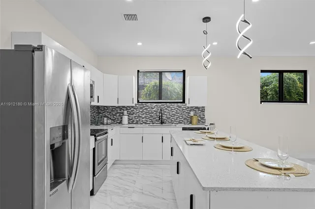 a kitchen with granite countertop a sink appliances and cabinets