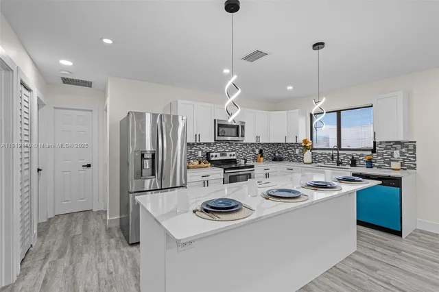 a kitchen that has a lot of cabinets a sink and a stove in it
