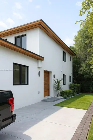 a white house with a yard and plants