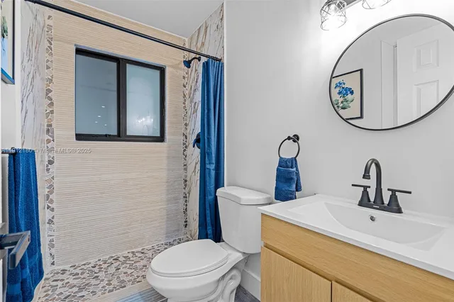 a bathroom with a toilet a sink and a mirror