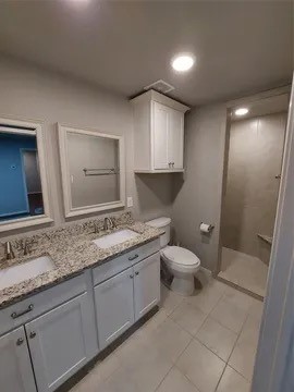 19103 Whitewood Drive Spring, TX 77373 - Photo 29 of 30 a bathroom with a granite countertop sink a toilet and a mirror