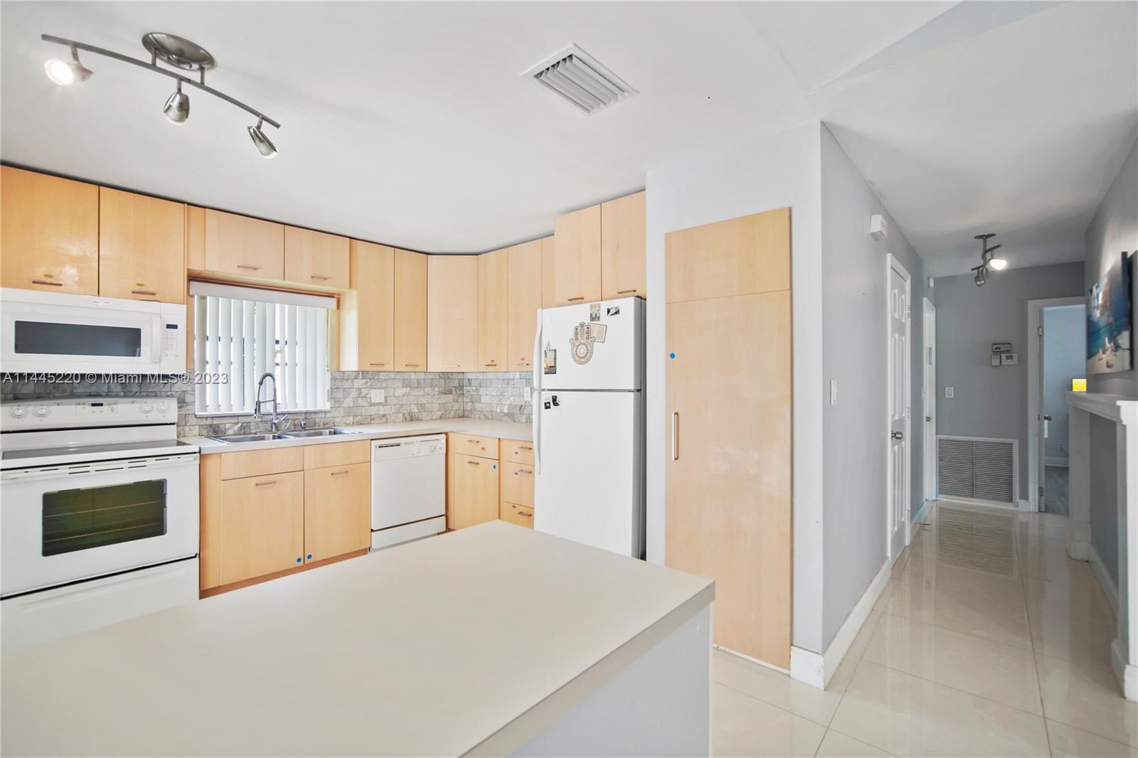 10161 Camelback Lane Boca Raton, FL 33498 - Photo 11 of 24 a kitchen with granite countertop white cabinets and white appliances