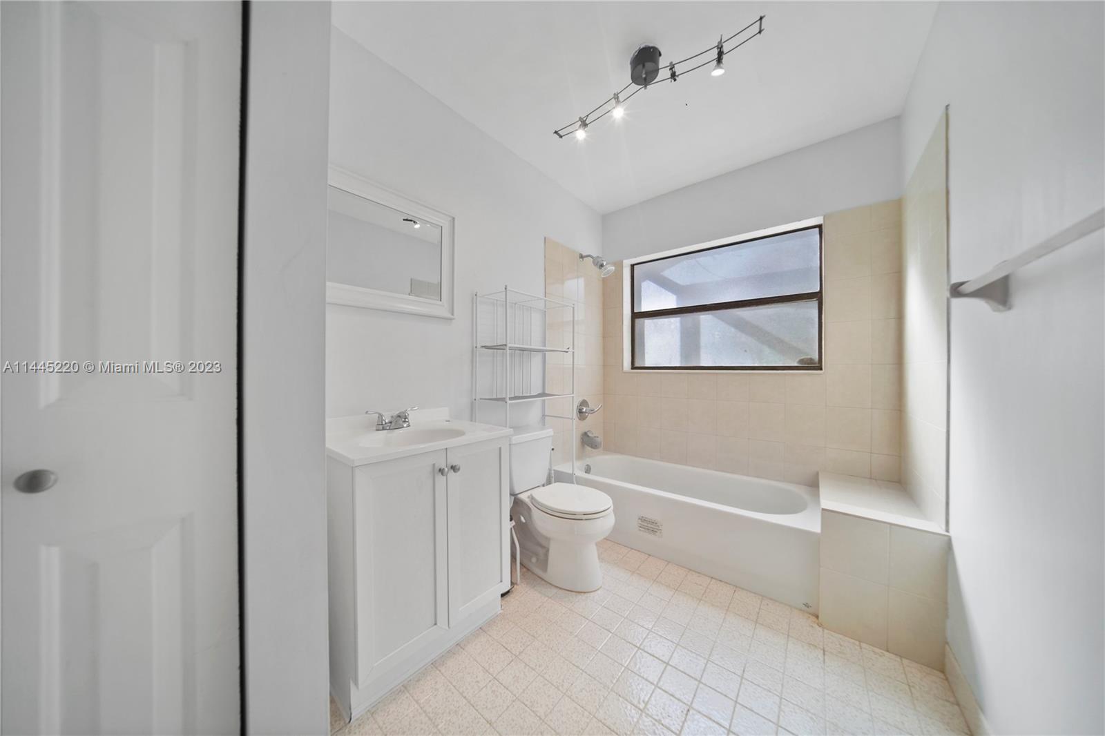 10161 Camelback Lane Boca Raton, FL 33498 - Photo 17 of 24 a bathroom with a toilet sink a mirror a shower and a bathtub