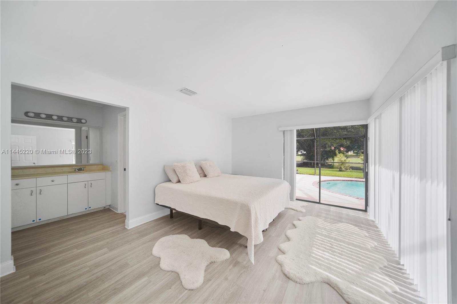 10161 Camelback Lane Boca Raton, FL 33498 - Photo 19 of 24 a spacious bedroom with a bed and a view of living room