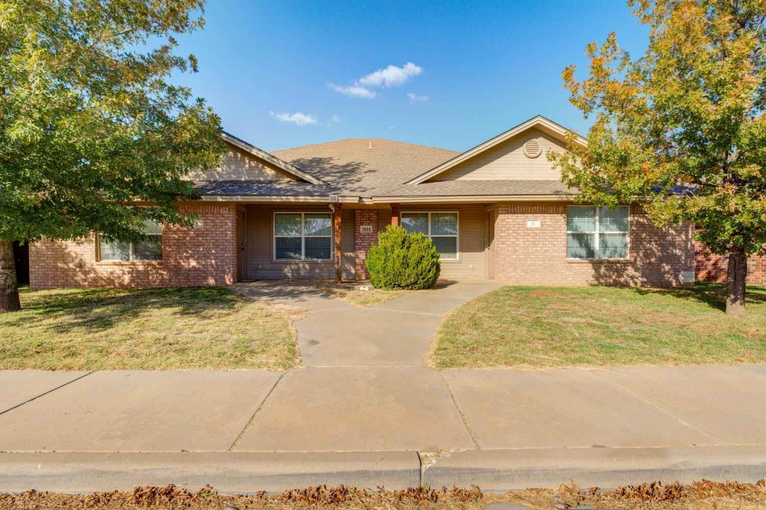 3114 109th Street Lubbock, TX 79423 - Photo 1 of 43 a view of a white house with a large tree and plants