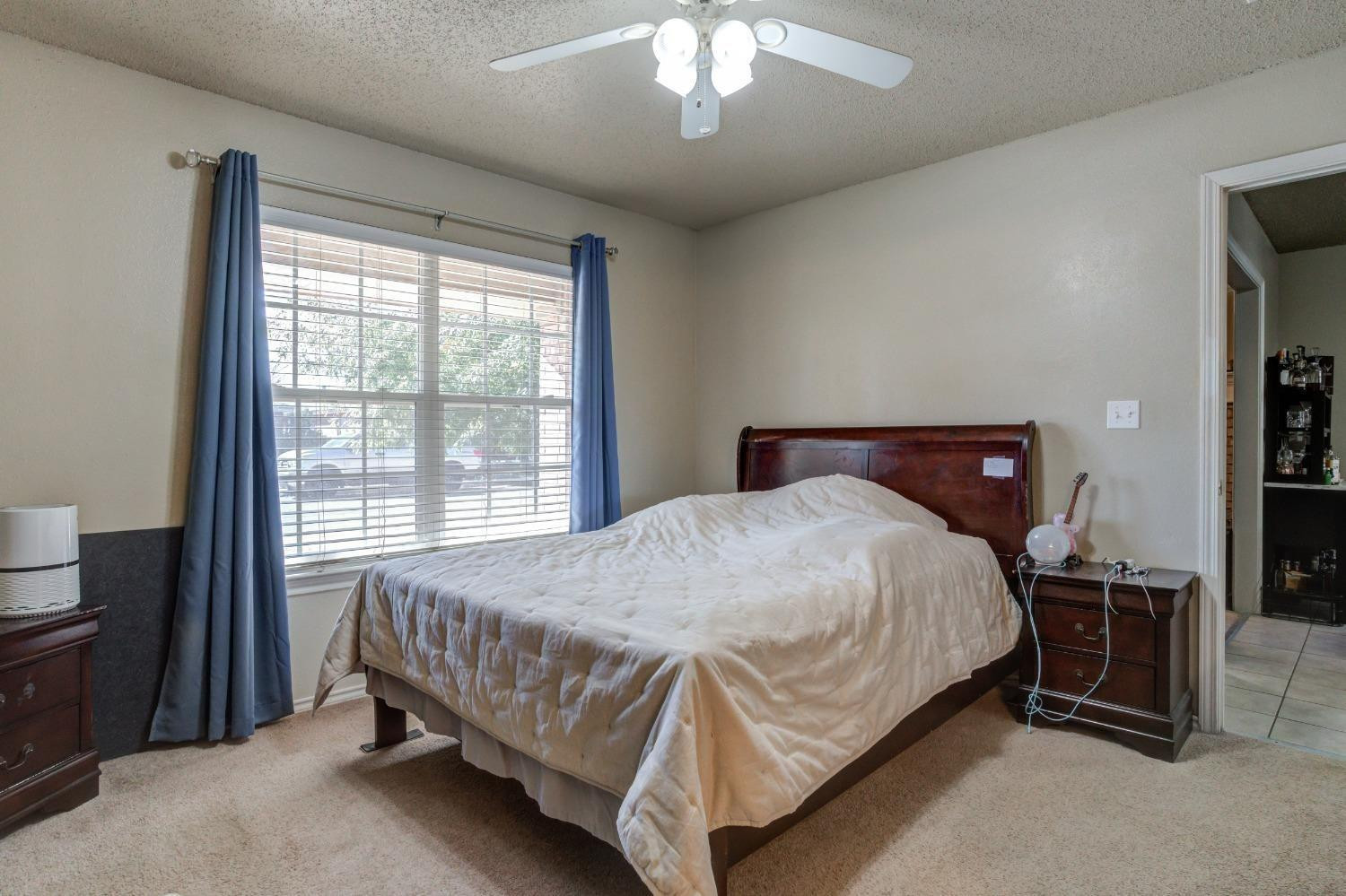 3114 109th Street Lubbock, TX 79423 - Photo 17 of 43 a bed sitting in a bedroom next to a window
