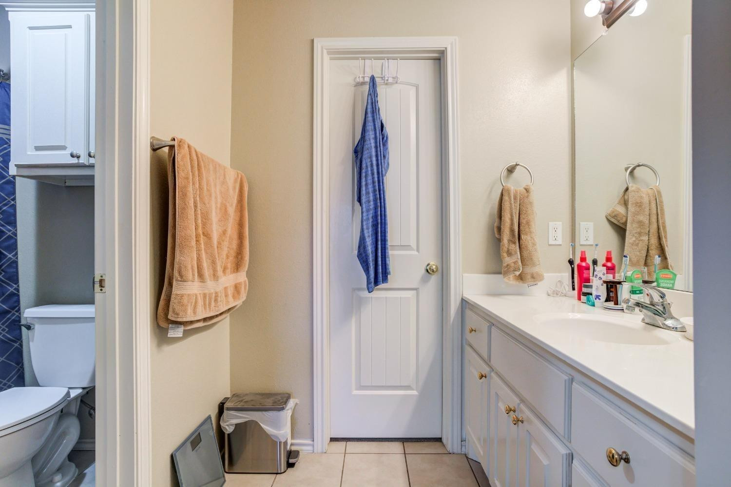 3114 109th Street Lubbock, TX 79423 - Photo 18 of 43 a bathroom with a sink vanity and a mirror