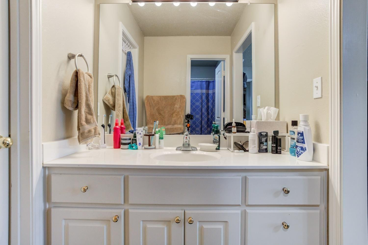 3114 109th Street Lubbock, TX 79423 - Photo 20 of 43 a bathroom with a sink and a mirror