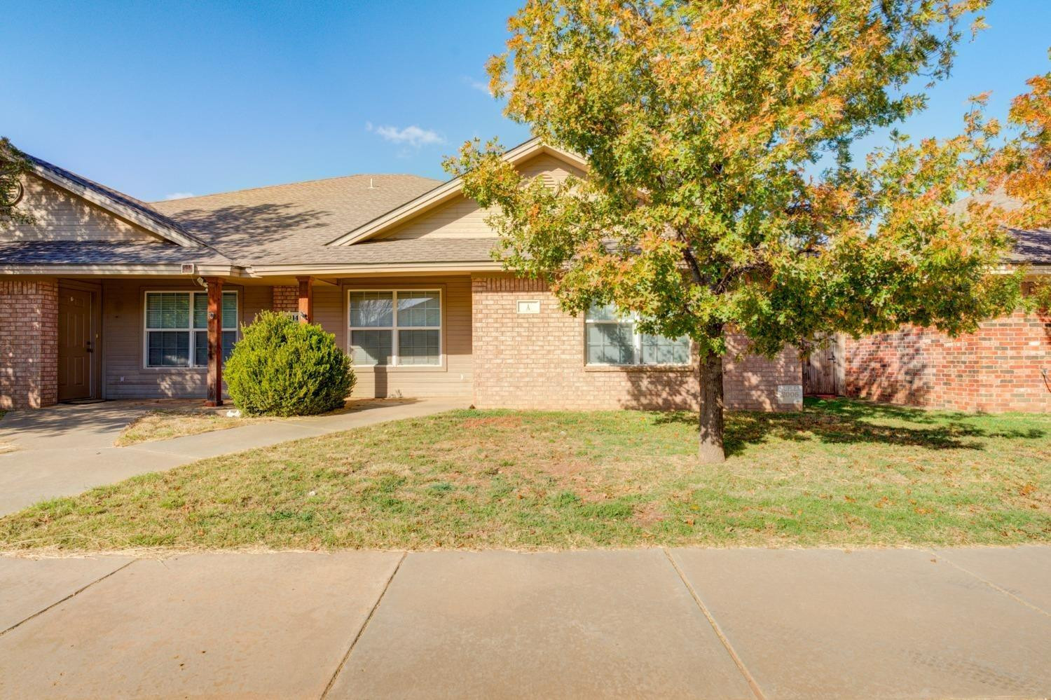 3114 109th Street Lubbock, TX 79423 - Photo 2 of 43 a front view of a house with a garden and tree