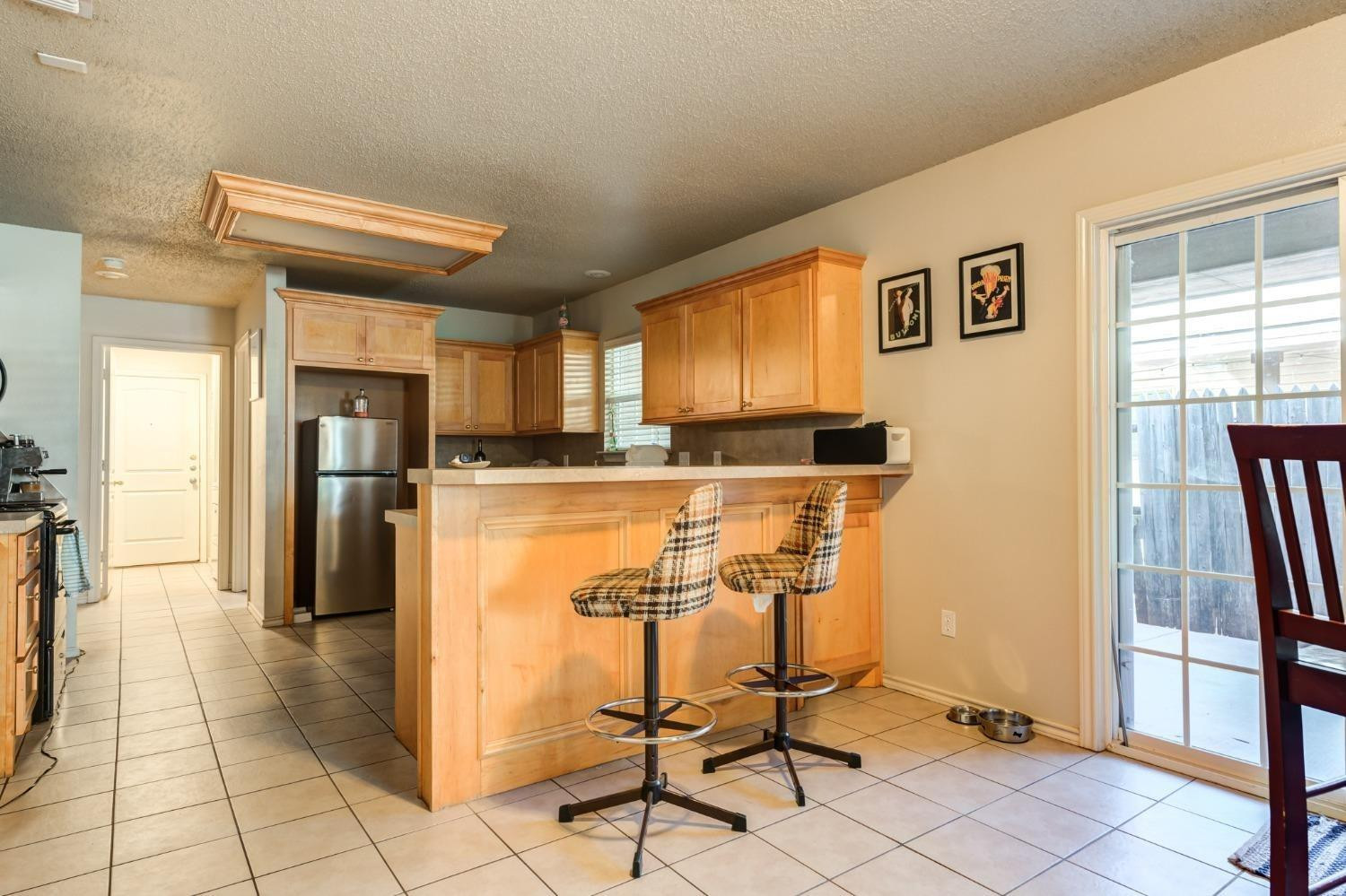 3114 109th Street Lubbock, TX 79423 - Photo 36 of 43 a kitchen with stainless steel appliances granite countertop a refrigerator and a stove top oven