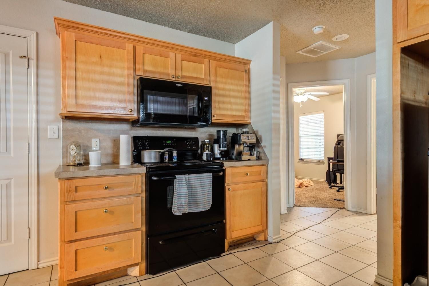 3114 109th Street Lubbock, TX 79423 - Photo 38 of 43 a kitchen with stainless steel appliances granite countertop a stove a sink and a microwave