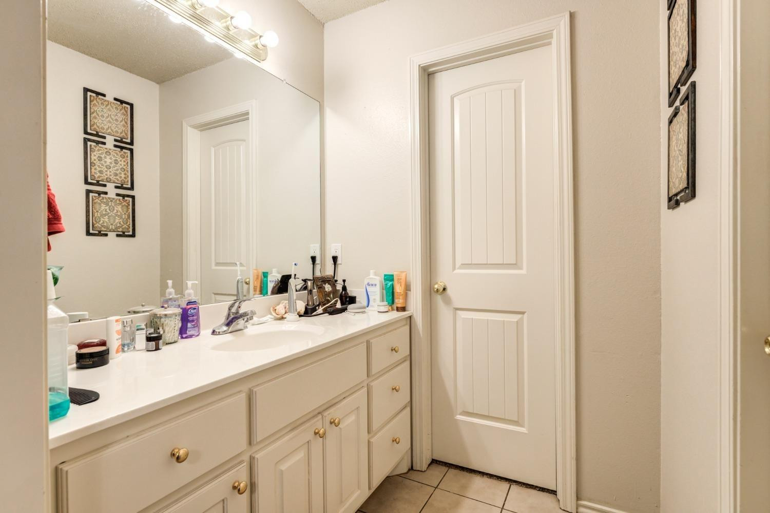 3114 109th Street Lubbock, TX 79423 - Photo 42 of 43 a bathroom with a sink and a mirror