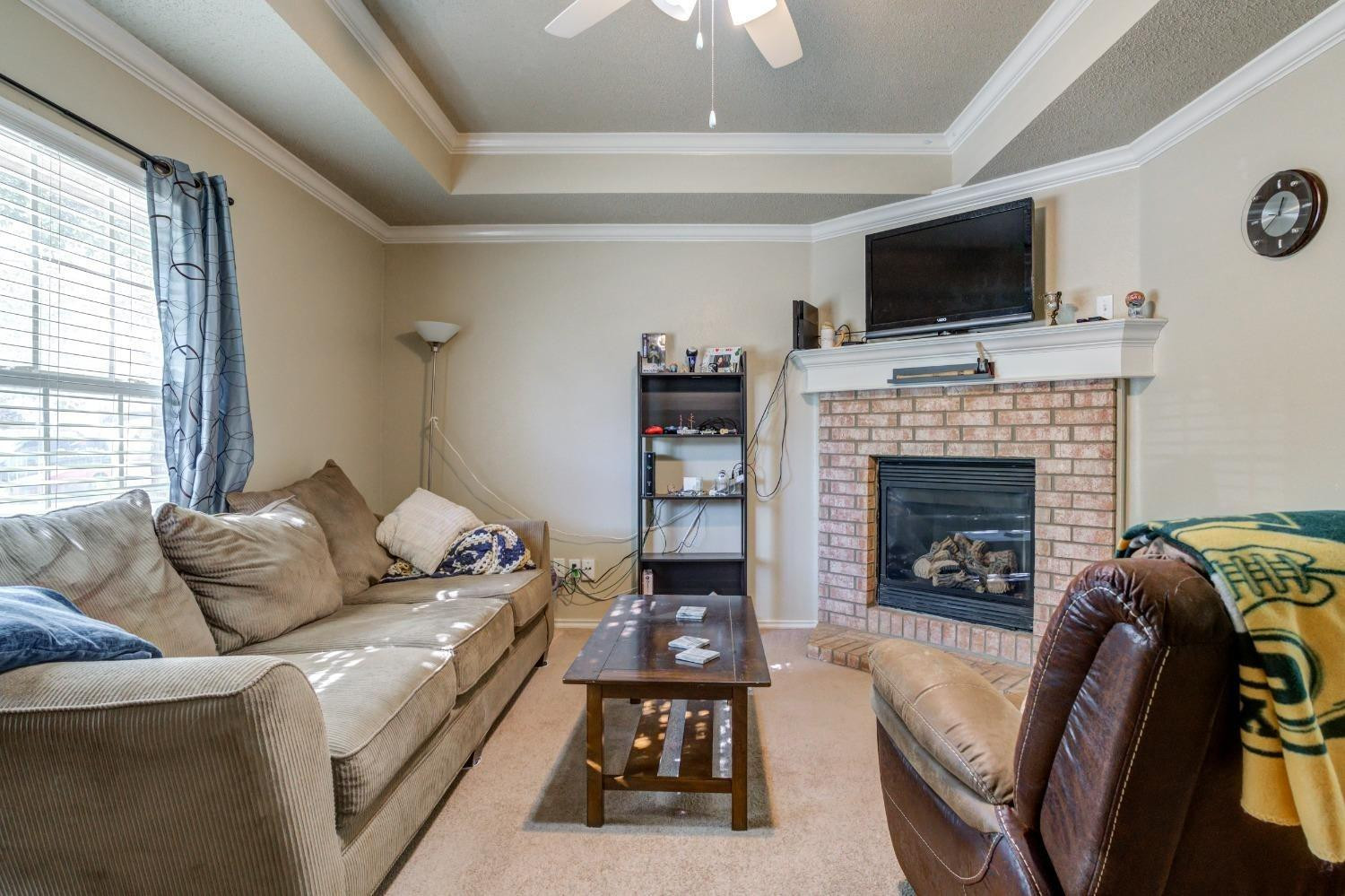 3114 109th Street Lubbock, TX 79423 - Photo 5 of 43 a living room with furniture and a fireplace