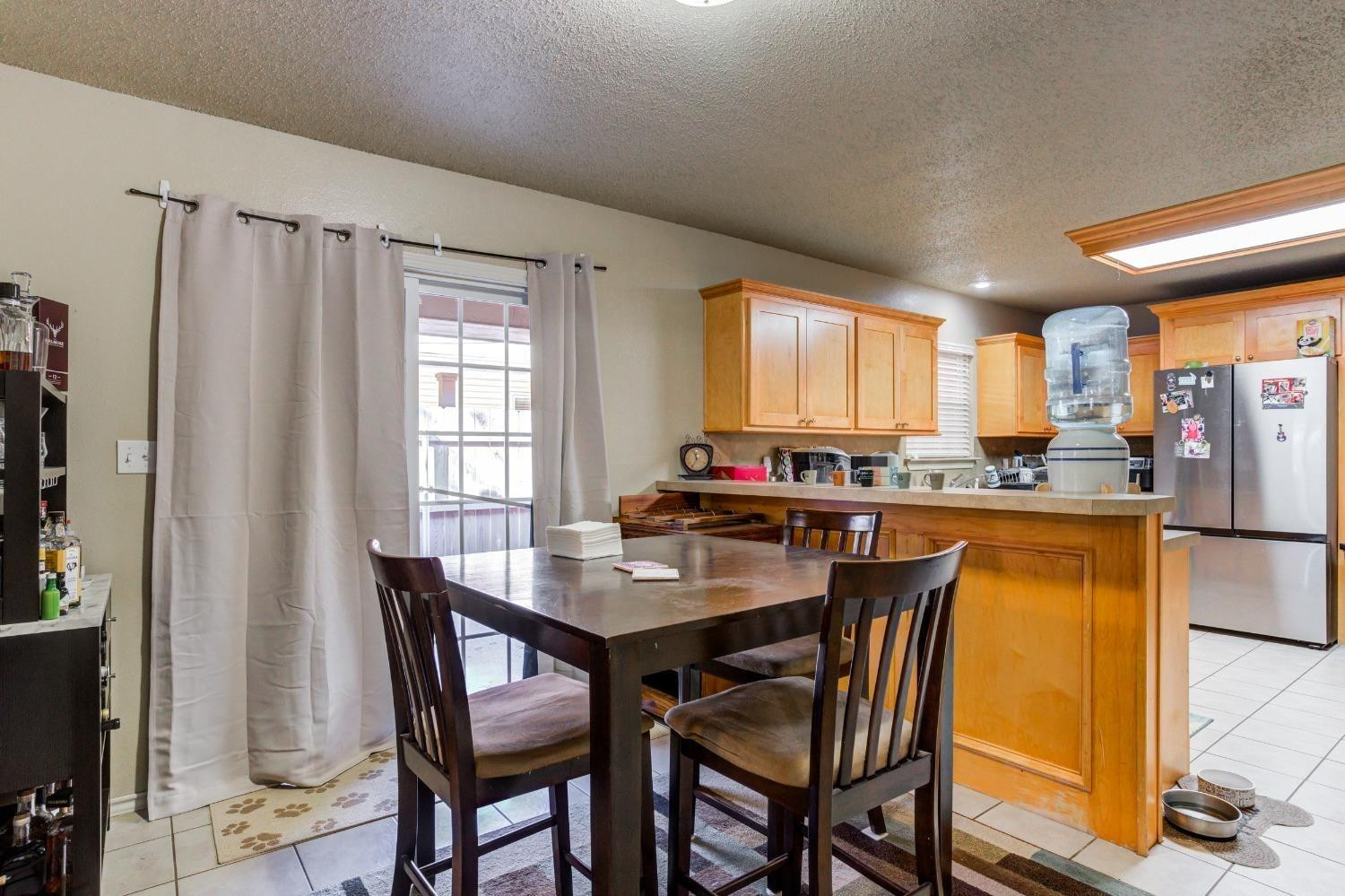 3114 109th Street Lubbock, TX 79423 - Photo 9 of 43 a dining area with stainless steel appliances granite countertop a table chairs and a refrigerator