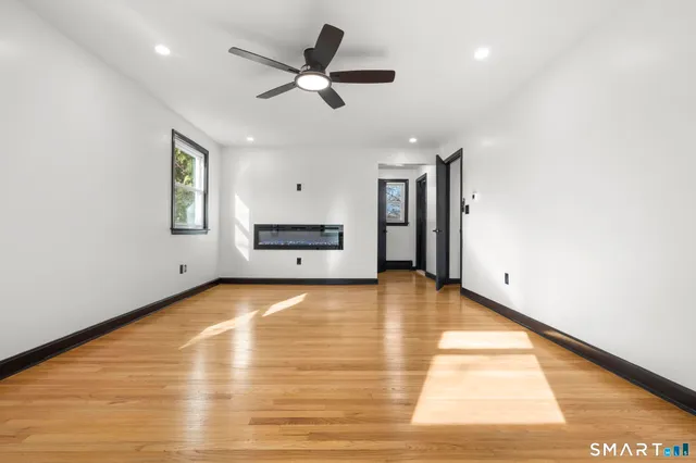 a view of empty room with wooden floor and window