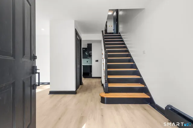 a view of entryway and hall with wooden floor