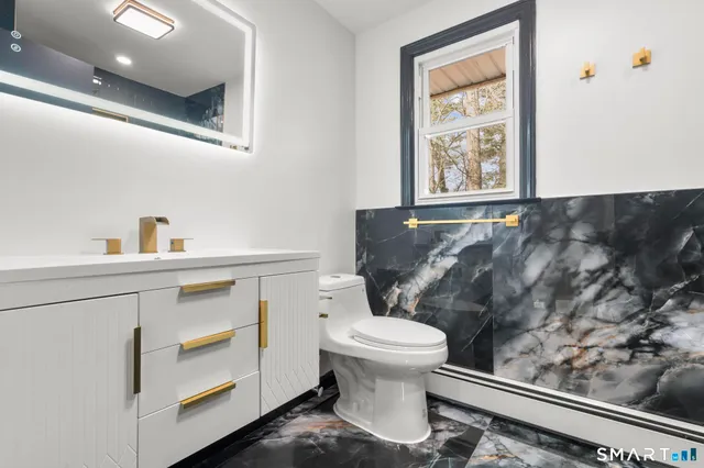 a bathroom with a toilet sink and mirror