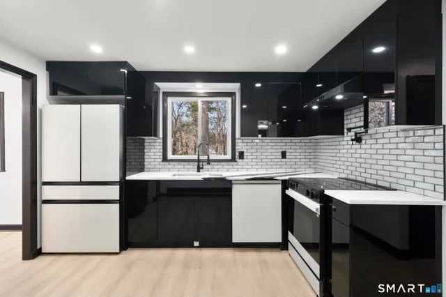 a kitchen with stainless steel appliances granite countertop a sink stove and refrigerator