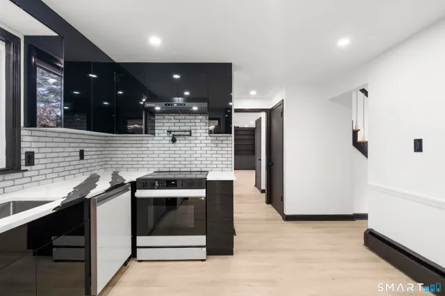 a kitchen with stainless steel appliances granite countertop a sink and a stove top oven