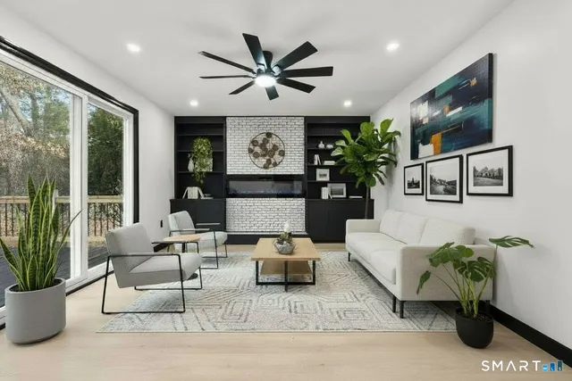 a living room with fireplace furniture and a large window
