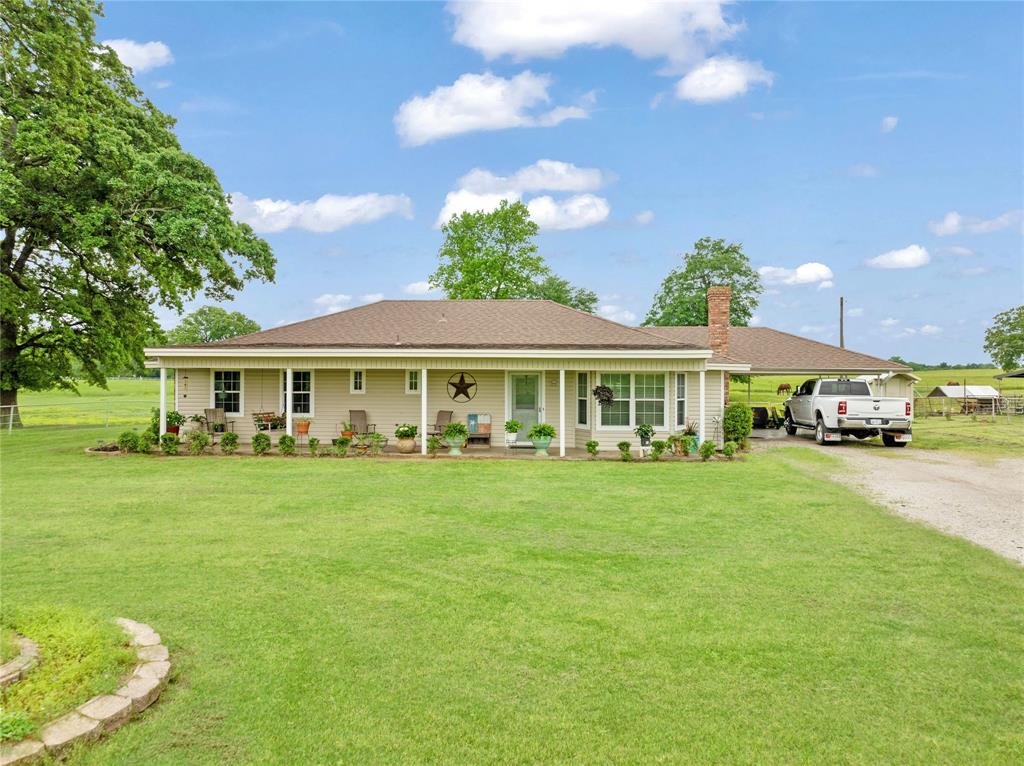 1355 County Road 33100 Sumner, TX 75486 - Photo 19 of 34 View of front of home with gravel driveway, a front yard, a chimney, and roof with shingles