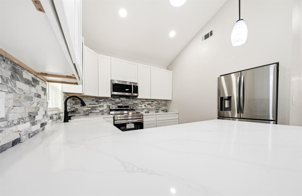 3313 South 3rd Street Waco, TX 76706 - Photo 6 of 28 a large white kitchen with stainless steel appliances