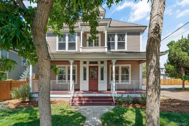 a view of house with a yard and large tree