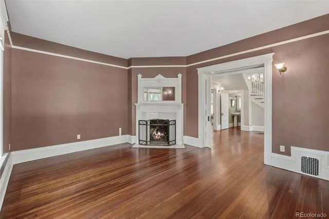 a view of a livingroom with wooden floor and a fireplace