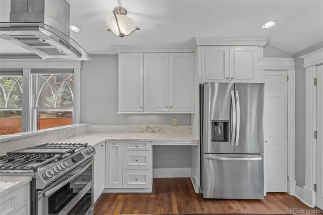 a kitchen with stainless steel appliances granite countertop a stove a refrigerator and a wooden cabinets