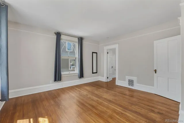 a view of an empty room with wooden floor