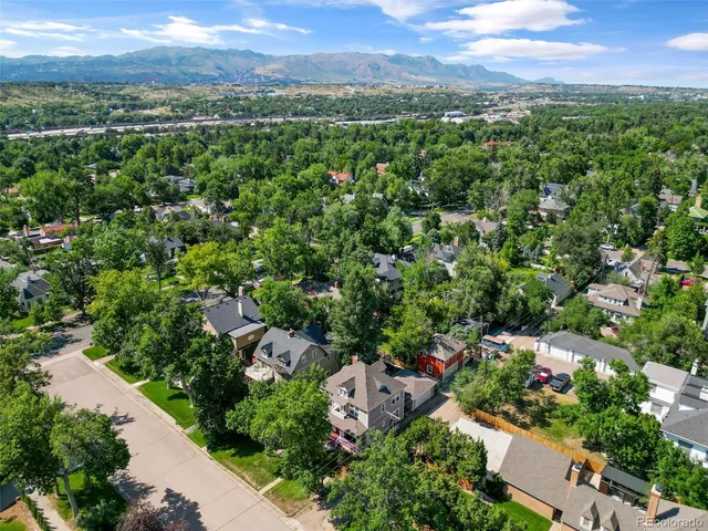 an aerial view of a city with lots of residential buildings and mountain view in back