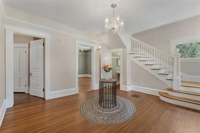 a view of hall way with dining room and wooden floor