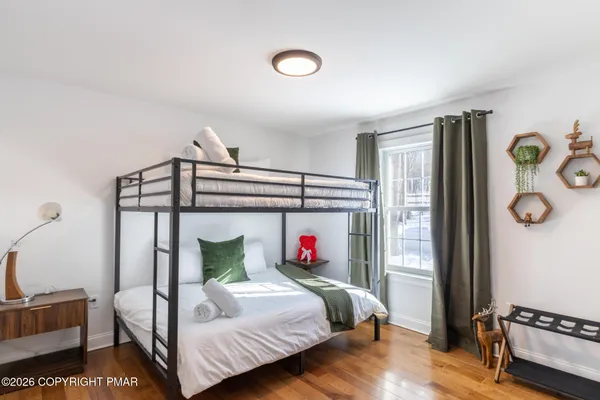 a bedroom with a bed and wooden floor