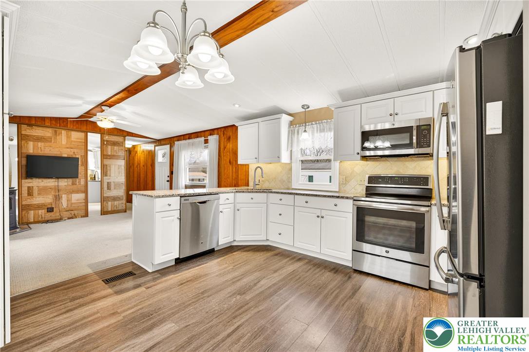 12 Revolutionary Road Mount Bethel, PA 18343 - Photo 14 of 53 a kitchen with granite countertop a refrigerator a stove a microwave and wooden floor