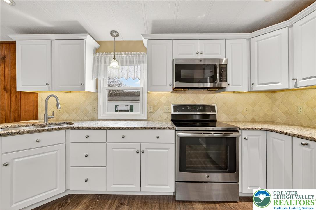 12 Revolutionary Road Mount Bethel, PA 18343 - Photo 7 of 53 a kitchen with granite countertop a stove a sink and a microwave