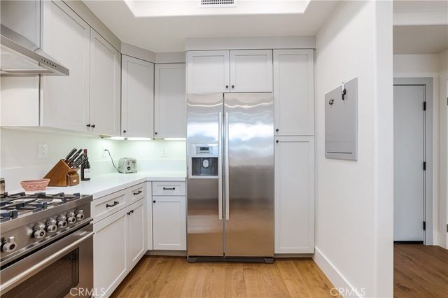 a kitchen with white cabinets and stainless steel appliances