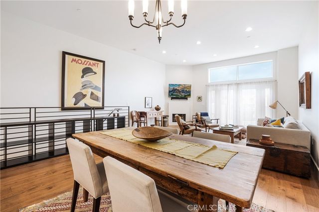 a view of a dining room with furniture a chandelier and wooden floor