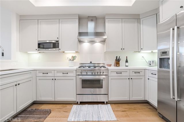 a kitchen with cabinets stainless steel appliances and a counter space