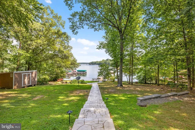 a view of a house with a big yard and large trees