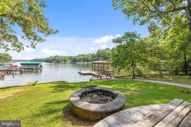 a view of swimming pool with lawn chairs and plants